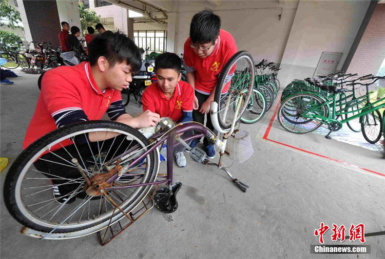 大学志愿者对收集整理来的“僵尸自行车”进行重新修整、喷漆,然后投放到校园公益自行车站点供师生们使用.jpg