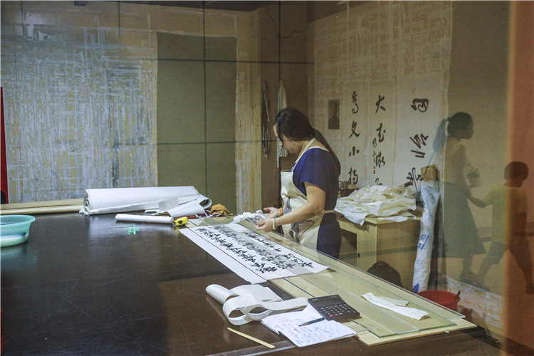 7为已经摆平好的字体从墙上用亲手做的竹刀将字画轻轻卸下后去掉多余的部分 (7).JPG