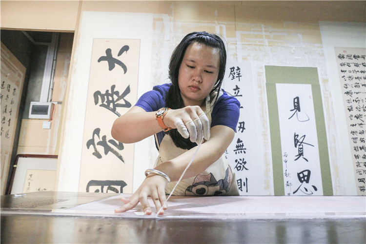 7为已经摆平好的字体从墙上用亲手做的竹刀将字画轻轻卸下后去掉多余的部分 (8).JPG